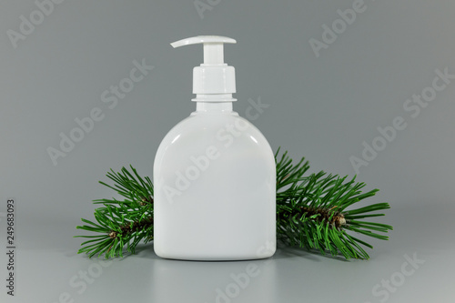white blank perfume dispenser bottle with pine tree branch on gray background © ronstik