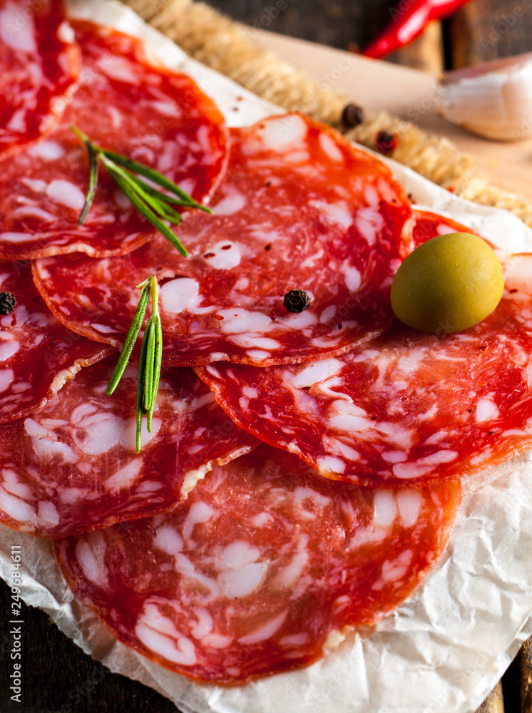 Chorizo sausage and salami, thin cut. spanish salami on the wood background with spices, paprika, pepper. Spicy food. Chili. Chorizo sausage and salami, thin cut. spanish salami on the wood background with spices, paprika, pepper. Spicy food. Chili.