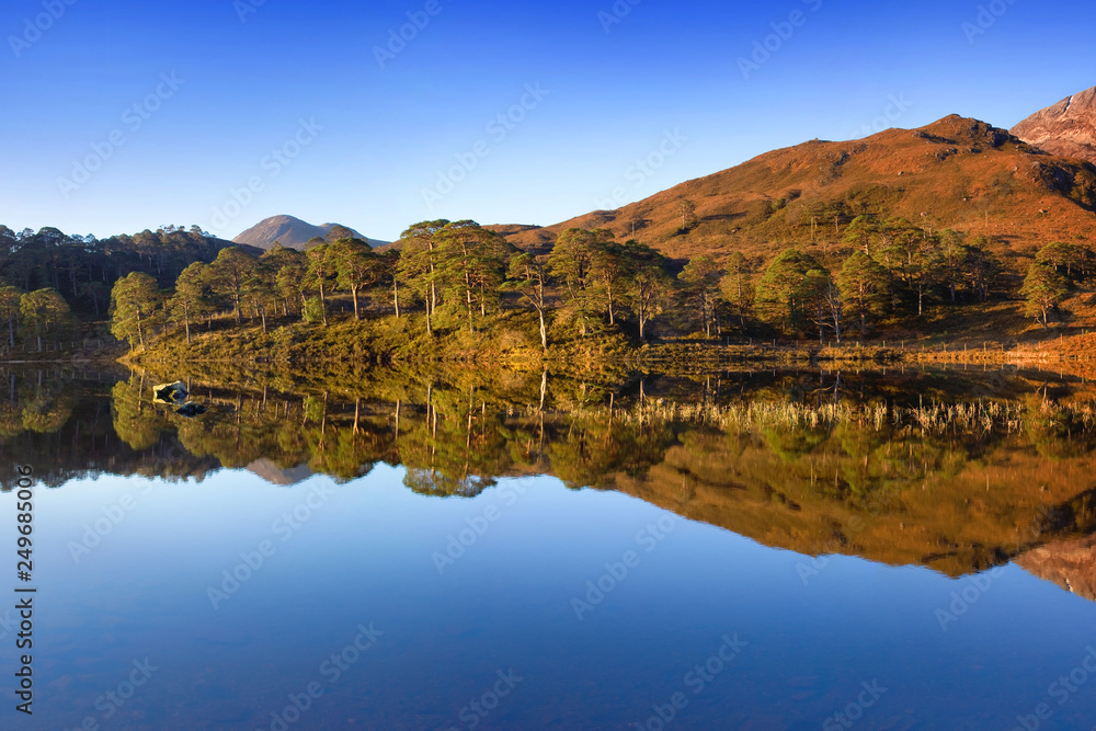 Fototapeta premium Autumn panorama of Loch Claire with the views of Beinn Eighe and Liathach from across the water. Glen Torridon, Highlands, Scotland, UK Beautiful landscape reflection in water 