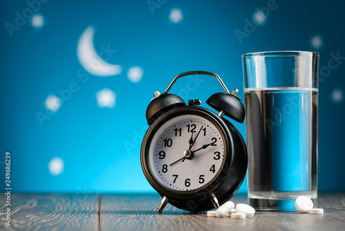 Alarm clock, pills and glass photo