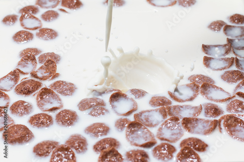 Brown conflakes in strawbery milk  white milk splash 