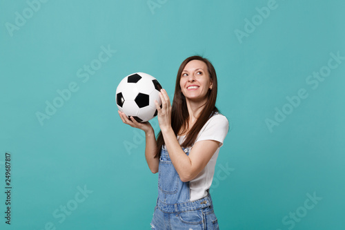 Pensive young woman football fan support favorite team with soccer ball looking up isolated on blue turquoise background. People emotions, sport family leisure lifestyle concept. Mock up copy space. © ViDi Studio