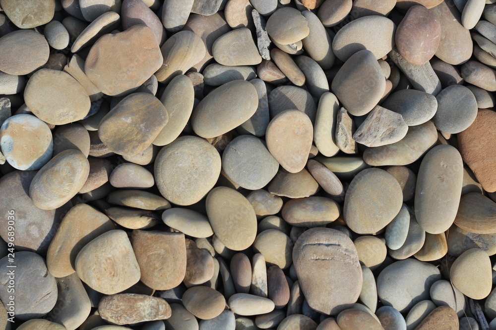 The texture of smooth sea stones of medium size. Beach and coastline. Place for the inscription. The texture of smooth sea stones of medium size. Beach and coastline. Place for the inscription.