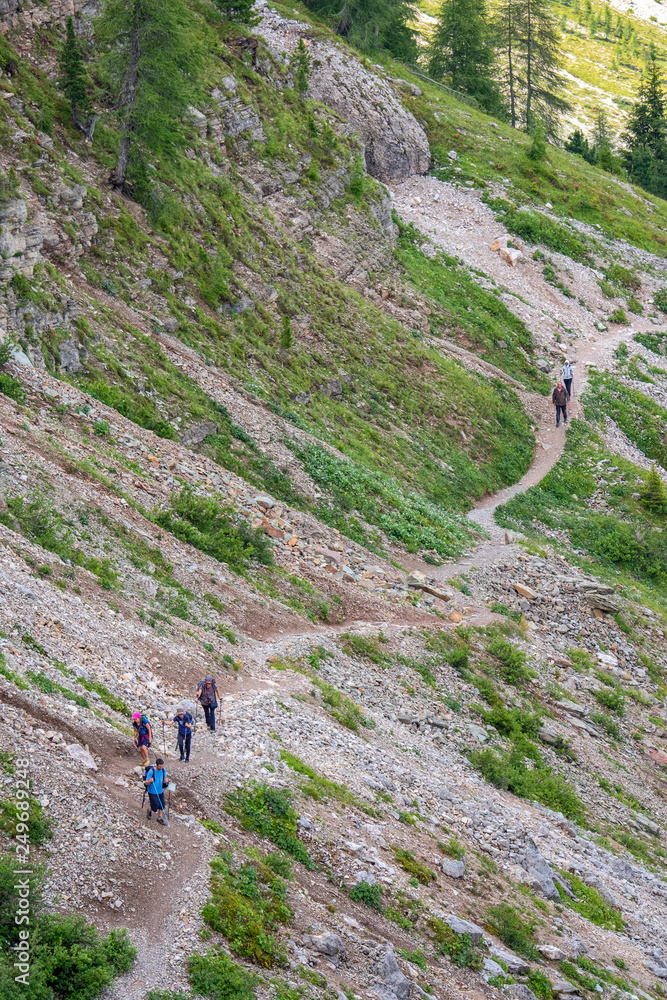 Hikers on a trail at a mountainside in the dolomites