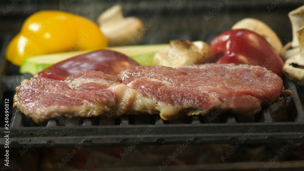Slow motion of steak, cooking steak with grilled vegetables