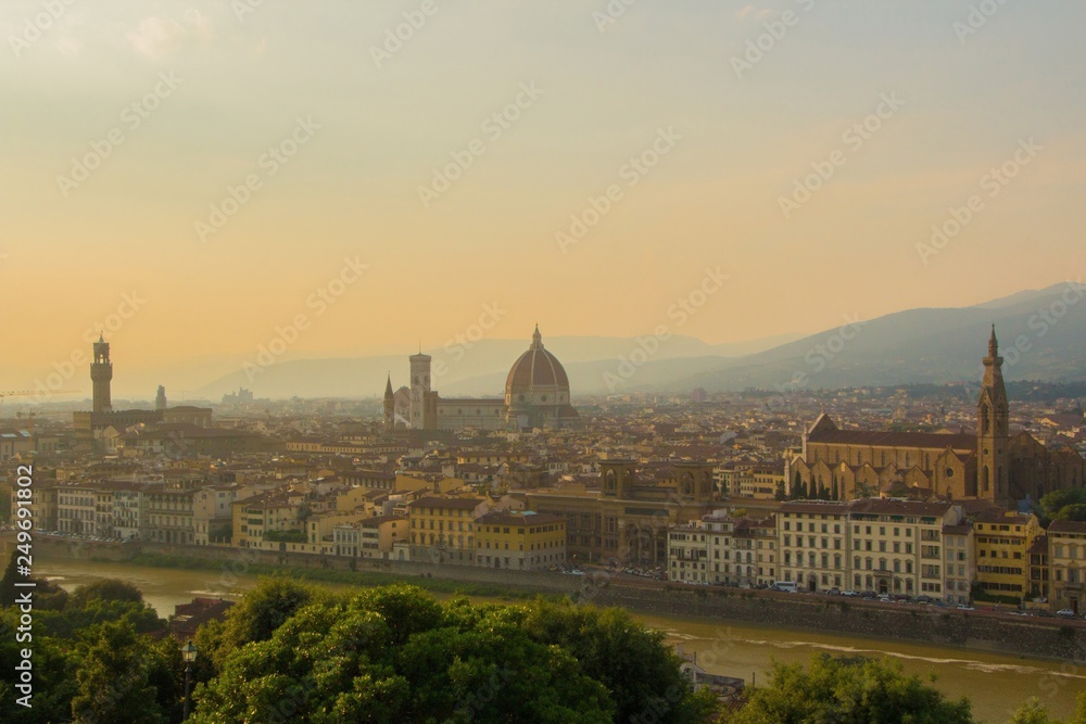 View of the Cathedral of Santa Maria del Fiore (Duomo), Basilica of Santa Croce, and Arnolfo tower of Palazzo Vecchio. Amazing evening golden hour light.  Florence, Italy.