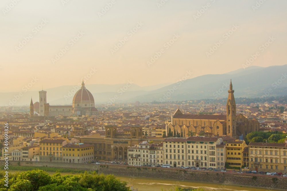 View of the Cathedral of Santa Maria del Fiore (Duomo) and Basilica of Santa Croce (Holy Cross). Amazing evening golden hour light. Beautiful gold sunset in Florence, Italy.