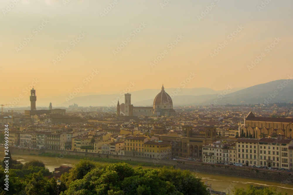 View of the Cathedral of Santa Maria del Fiore (Duomo), Basilica of Santa Croce, and Arnolfo tower of Palazzo Vecchio. Amazing evening golden hour light. Florence, Italy.
