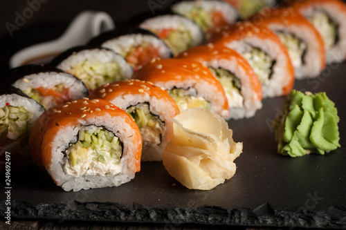 Maki rolls and nigiri sushi on a wooden table. Salmon, avocado and caviar rolls.