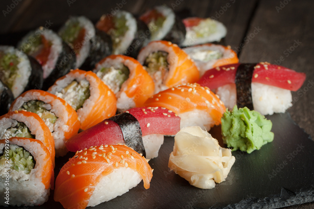Maki rolls and nigiri sushi on a wooden table. Salmon, avocado and caviar rolls. Maki rolls and nigiri sushi on a wooden table. Salmon, avocado and caviar rolls.