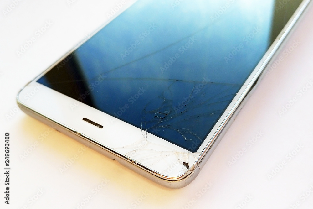 Broken screen white mobile smartphone with scratches on light background. Crashed cellphone display. Close up photography Broken screen white mobile smartphone with scratches on light background. Crashed cellphone display. Close up photography