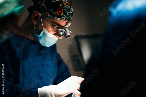 Portrait of surgeon performing in operation theatre. Close up portrait of surgical doctor performing operation in surgery room. photo