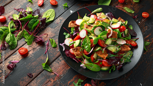 Photo Traditional fattoush salad on a plate with pita croutons, cucumber, tomato, red