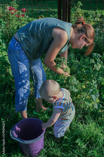2009.07.18, Kaluga, Russia. Mother and her son gardening in summer day. Little boy helping his mother in the garden.