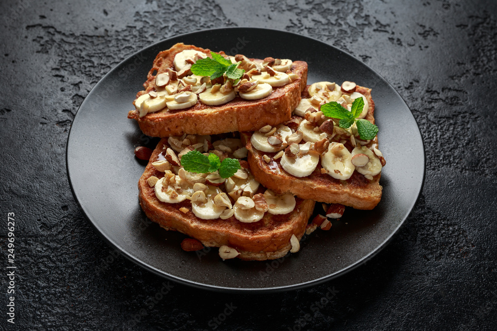 French cinnamon toast with banana, nuts and hazelnut, honey. French cinnamon toast with banana, nuts and hazelnut, honey.