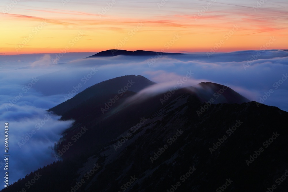 Beautiful sunset on the highest peak and colorful golden red sky, Krkonose (Giant Mountains), Czech Republic Autumn above the clouds, inversion in mountains. Amazing landscape background concept