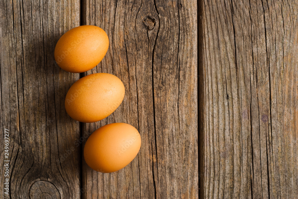 three eggs on weathered wooden table three eggs on weathered wooden table