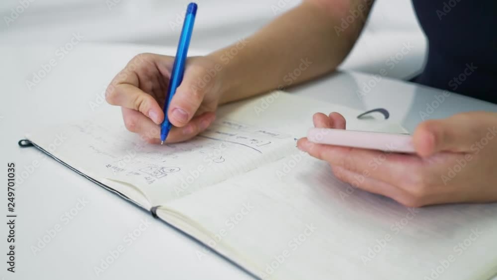 Close up of businesswoman hands witn smartphone writing in notepad. Work and communication concept. HD Slow motion Close up of businesswoman hands witn smartphone writing in notepad. Work and communication concept. HD Slow motion
