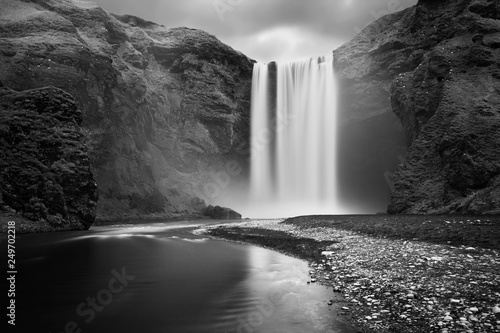 Iceland waterfall Skogafoss in Icelandic nature landscape. Famous tourist attractions and landmarks destination in Icelandic nature landscape on South Iceland. Classic long exposure.