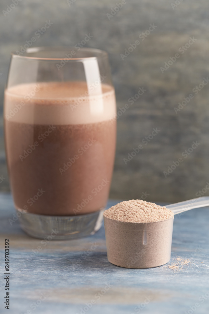 Foto de Scoop of Whey Protein and a Glass of Chocolate Protein Shake with  milk and banana. Sport nutrition. Wooden background. Copy space. do Stock |  Adobe Stock