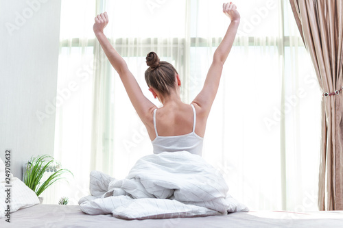 Wallpaper Mural Young woman stretching herself in bed at home and trying to waking up early in the morning for start new day Torontodigital.ca