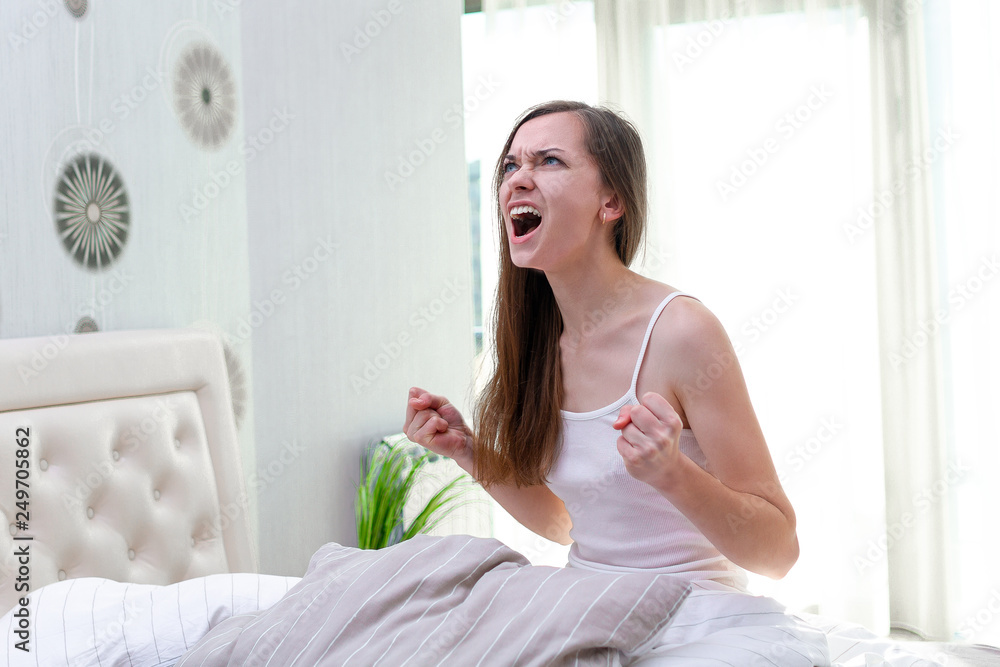 Angry screaming woman suffering and disturbed from noisy neighbors and trying to falling asleep in bed at home in early morning. noisy concept Angry screaming woman suffering and disturbed from noisy neighbors and trying to falling asleep in bed at home in early morning. noisy concept