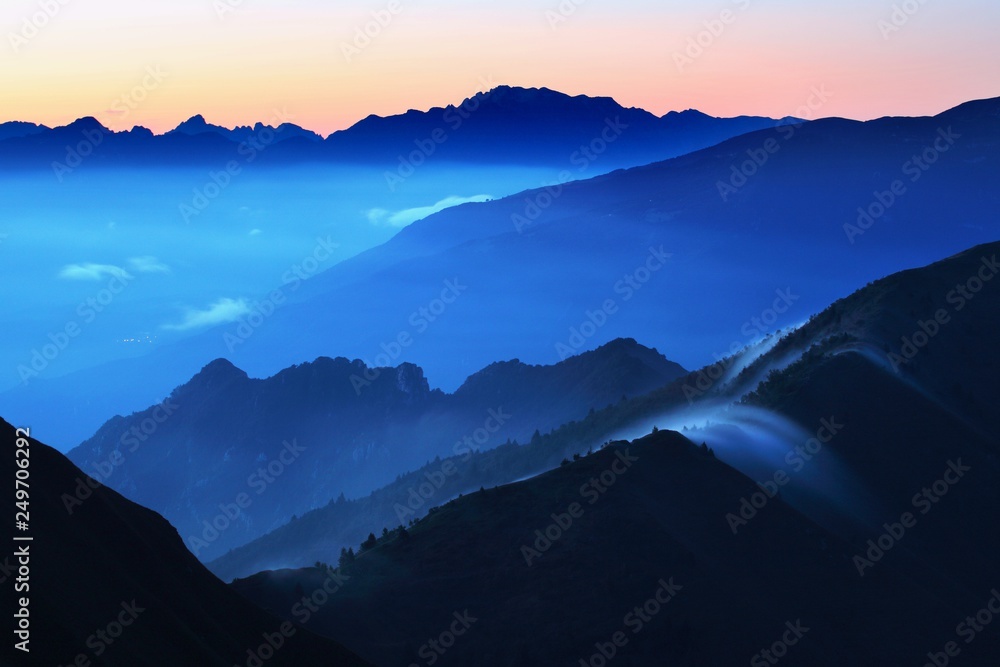 Panoramic view of idyllic mountain scenery in the Alps with fresh green meadows on a beautiful sunny day in springtime, panoramic view of mountains at border of France and Swiss and Italy