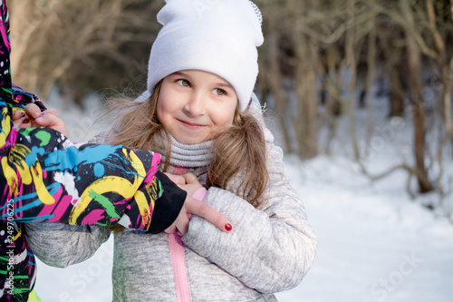 portrait of a beautiful little girl in winter park lifestyle dress