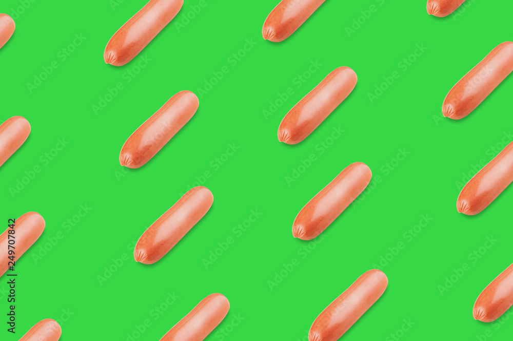 Diagonal rows of prepared long sausages on green background Diagonal rows of prepared long sausages on green background