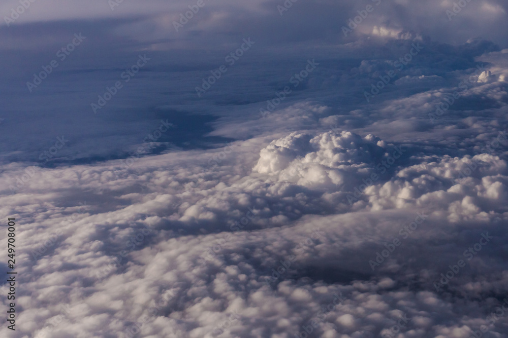 Naklejka premium White clouds and blue sky from an airplane