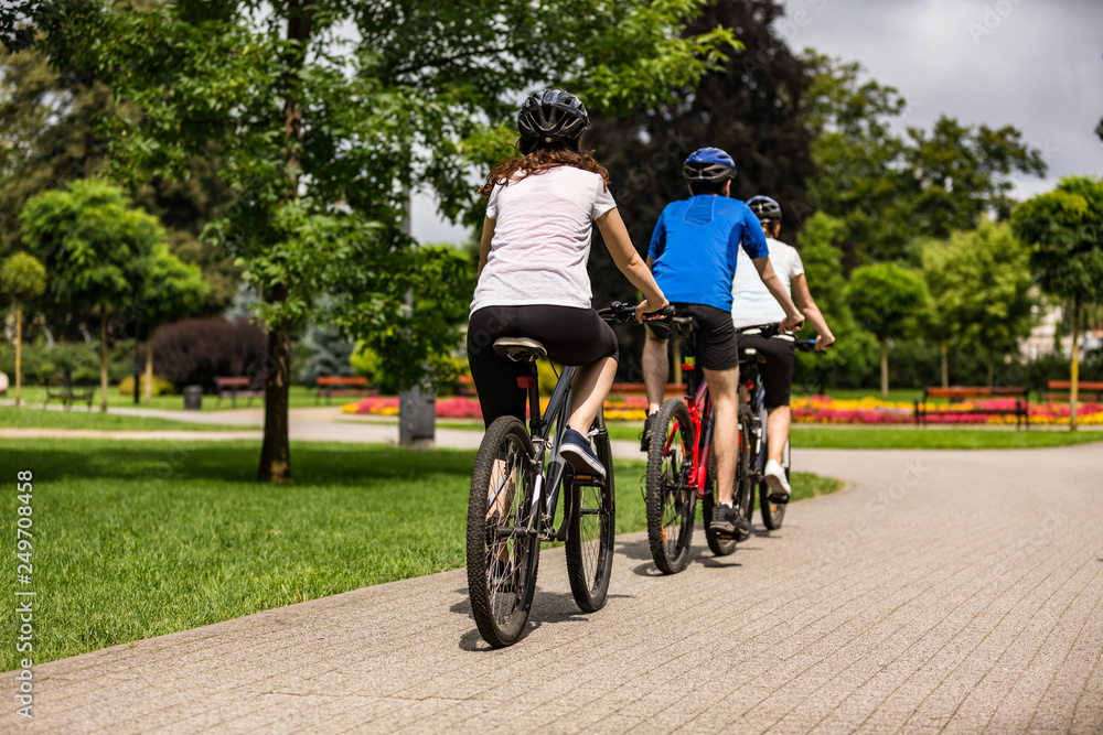 Healthy lifestyle - people riding bicycles in city park Healthy lifestyle - people riding bicycles in city park