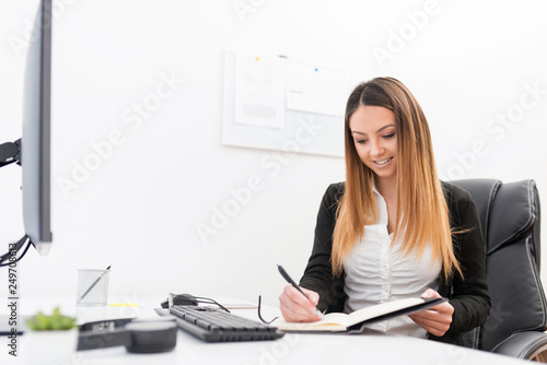 A beautiful young manager performs her regular duties in her office. © Bojan Topalovic