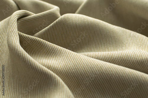 Fototapeta Naklejka Na Ścianę i Meble -  beige fabric closeup. Smooth soft curves of the fabric. Can be used as background.