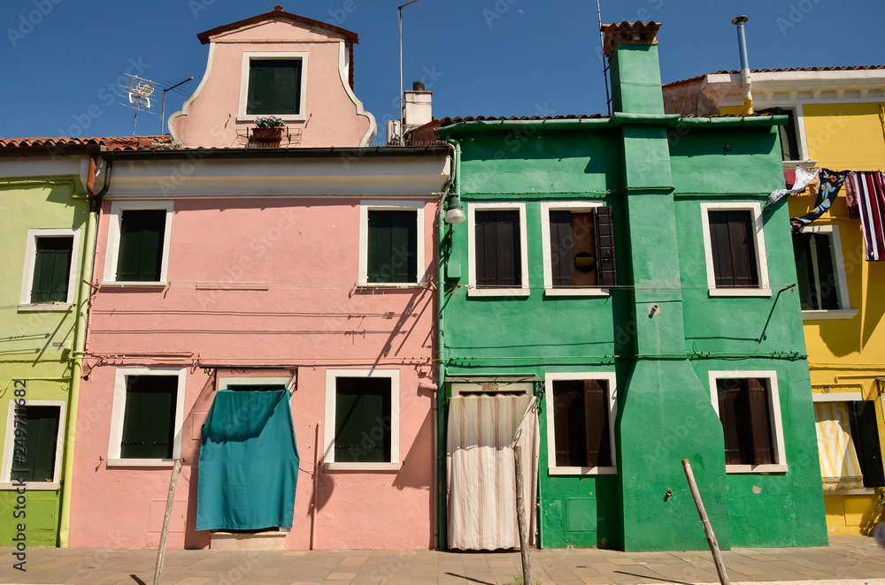 Traditional colourful painted houses on the island of Burano, Venice, Italy. The island is a popular attraction for tourists due to its picturesque architecture