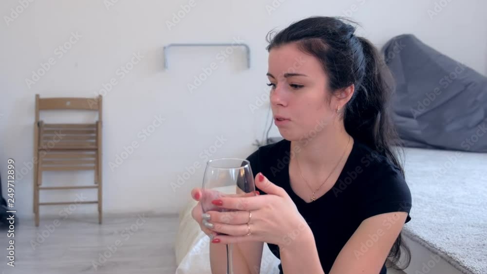 Woman with a glass of red wine in her hand is talking to someone. Woman with a glass of red wine in her hand is talking to someone.
