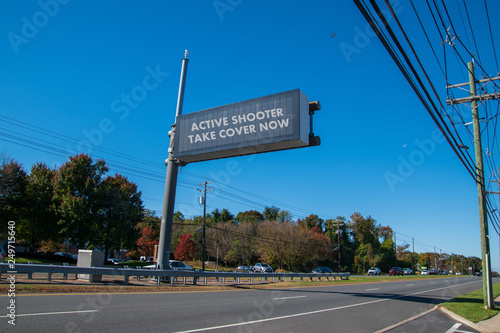 Fotografie Electronic sign over highway that says, Active Shooter Take Cover Now