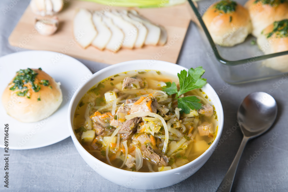 Shchi (cabbage soup) with buns (pampushki), fat and garlic. Traditional Russian and Ukrainian soup. Selective focus, close-up. Shchi (cabbage soup) with buns (pampushki), fat and garlic. Traditional Russian and Ukrainian soup. Selective focus, close-up.