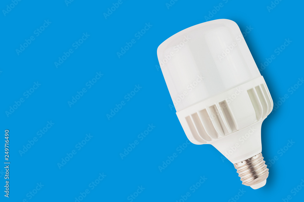 One new plastic led bulb on blue background with copy space. Saving and economy or green energy concept. Top view One new plastic led bulb on blue background with copy space. Saving and economy or green energy concept. Top view