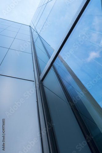 detail of modern office building with glass and steel reflecting blue sky