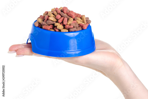 Dry food in a bowl for dogs and cats in hands on a white background isolation