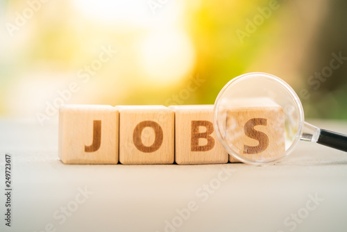 Wood block word JOB and magnifying glass with copy space using as background Choice of the best suited employee, HR, HRM, HRD, job recruiter concepts. photo