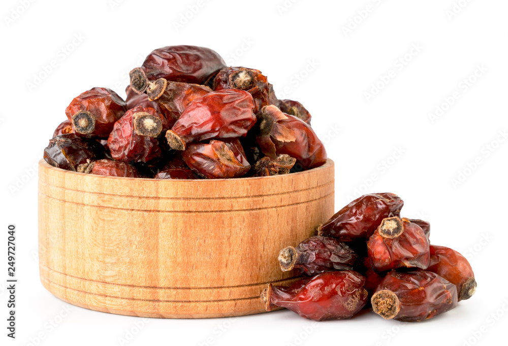Dried rose hip in wooden plate close-up on a white. Isolated. Dried rose hip in wooden plate close-up on a white. Isolated.