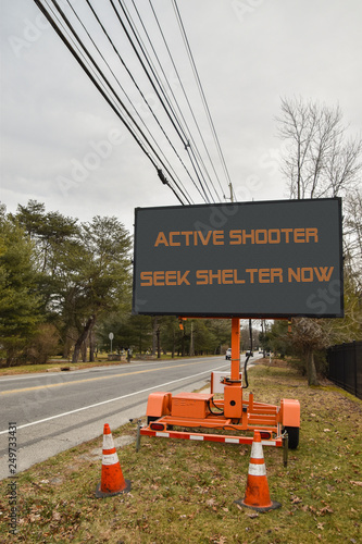 Canvas-taulu Electronic sign near a road that says, Active Shooter Take Cover Now
