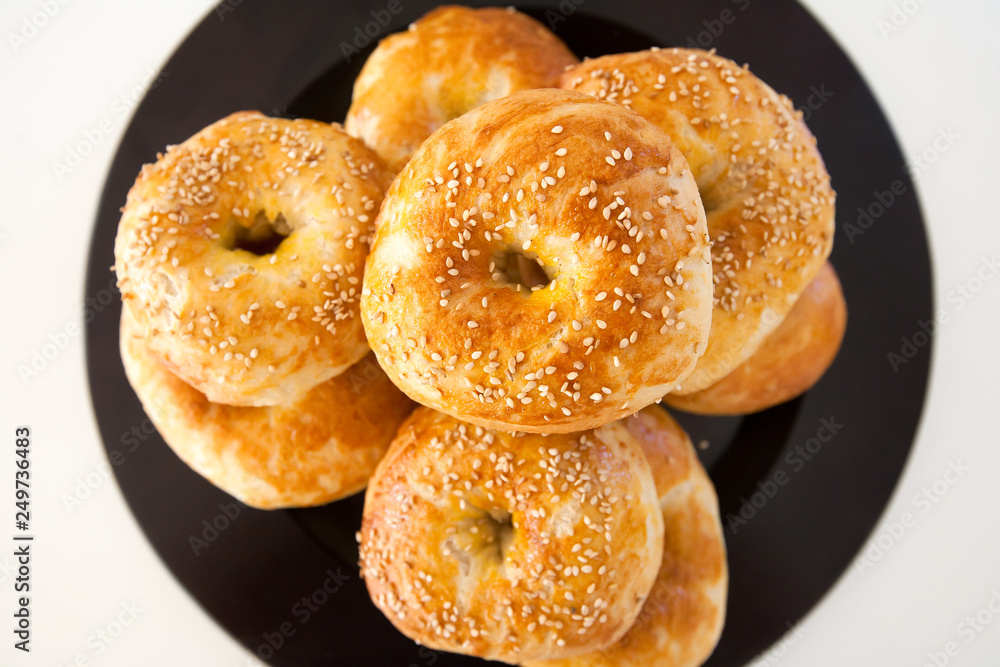 Fresh baked bagle buns with sesame seeds on white background
