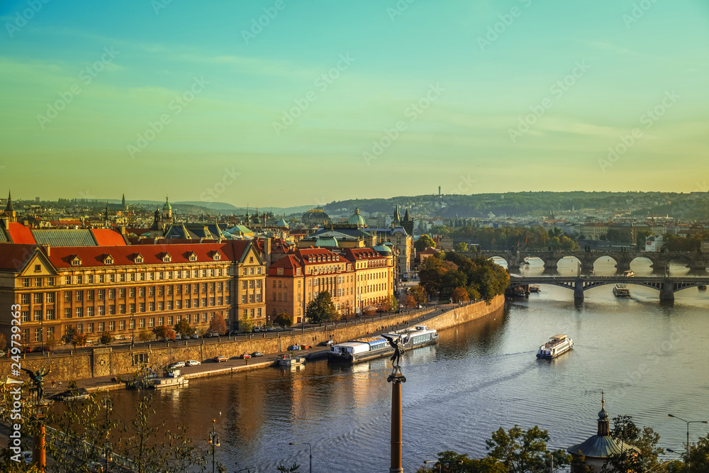 View of Charles bridge and the old town of Prague in Czech Republic, at the banks of Vltava River under the sunset