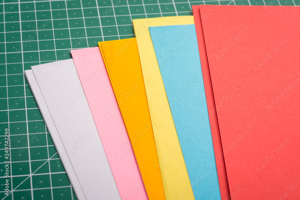 Papers for art of different size on green cutting mat Papers for art of different size on green cutting mat