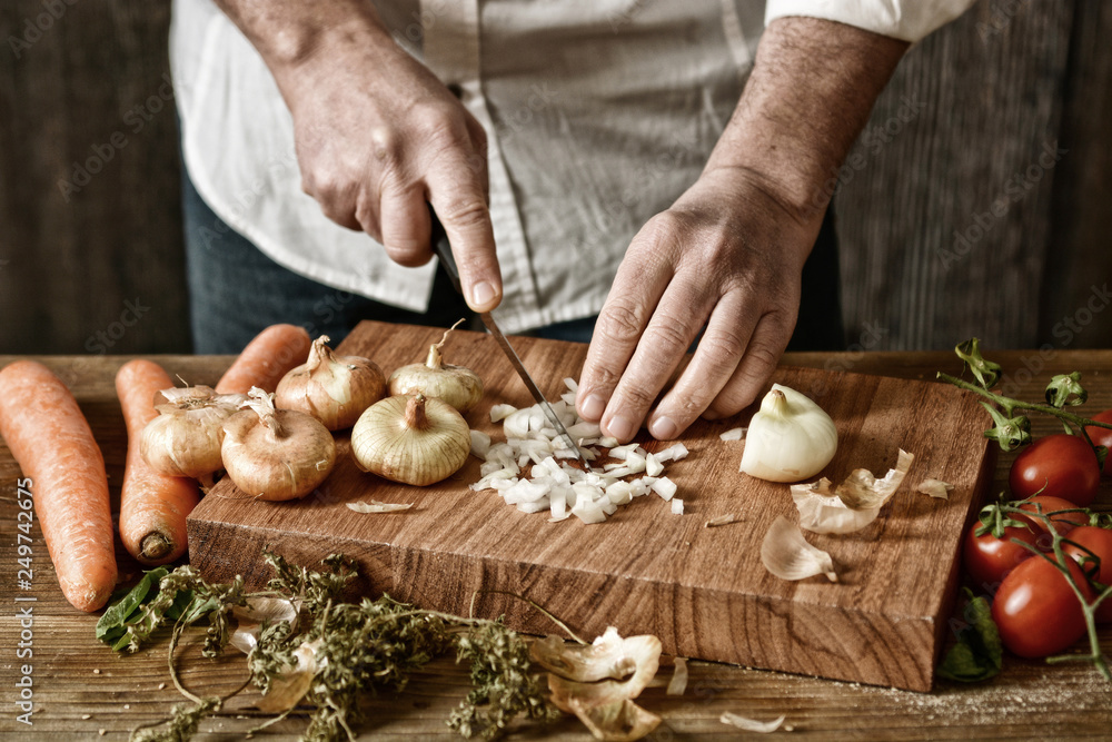 chop onion on wooden chopping board - healthy and traditional eating - desaturated effect - selective focus - closeup