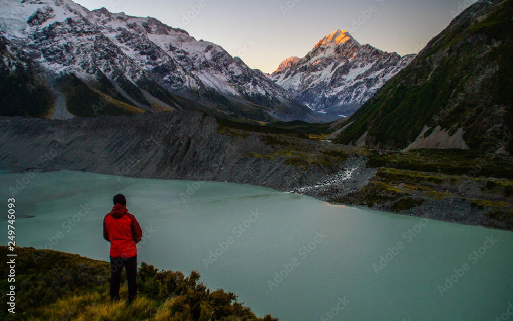 Travel New Zealand.Young tourist/hiker man enyjoing scenic snowy mountain views on Hooker Valley walking track. Popular tourist attraction/destination in Aoraki/mount Cook National Park,South Island. 