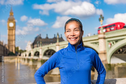 London city healthy active fitness woman running near Big Ben. Female runner girl jogging training. Asian athlete smiling happy on Westminster Bridge, London, England, United Kingdom.