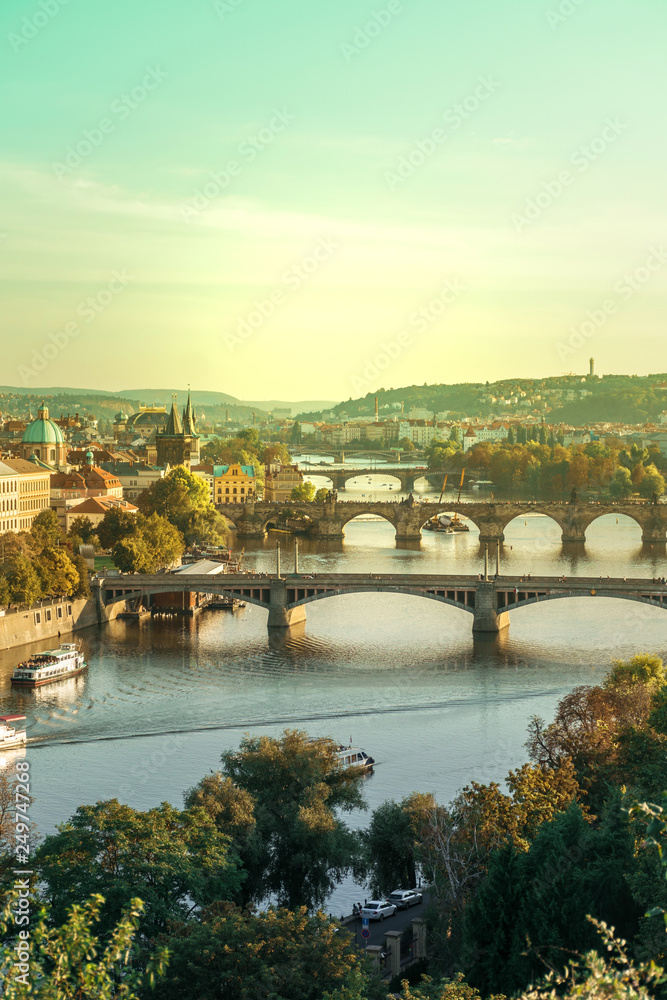 View of Charles bridge and the old town of Prague in Czech Republic, at the banks of Vltava River under the sunset